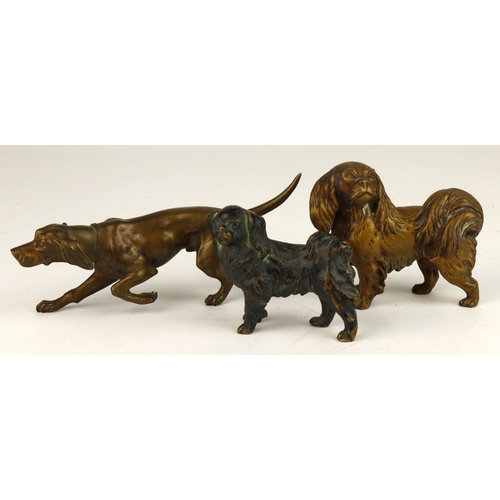 522 - Three bronze miniature dog sculptures. Two Pekinese, along with a Pointerwith elevated front paw (ev... 