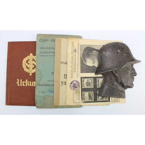 1156 - German WW2 ID booklets, passes and a metal bust of a German soldier.