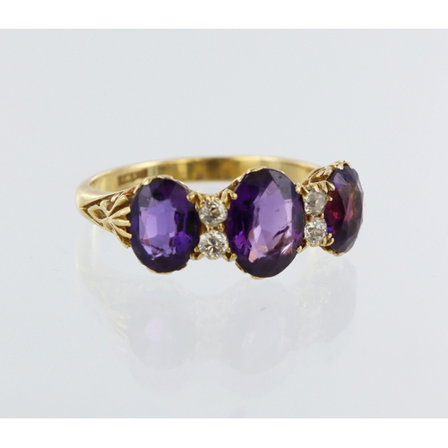 127 - Yellow metal (stamped 18ct) amethyst and diamond ring, three oval amethysts, four round brilliant cu... 