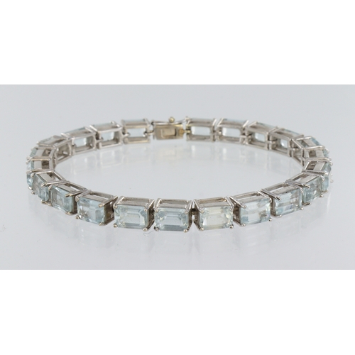 334 - White metal (stamped 9ct) aquamarine line bracelet, twenty two step cuts, length 18cm, weight 20.0g