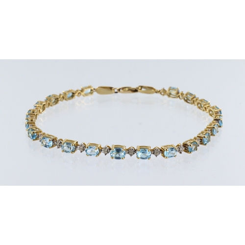 427 - Yellow metal (stamped 14ct) yellow gold blue topaz and diamond line bracelet, twenty one oval topaz,... 