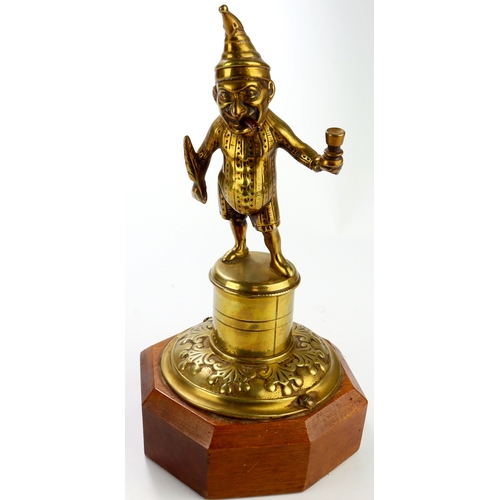 419 - Brass Mr Punch table / counter lighter, mounted on an octagonal plinth, total height 24cm approx.