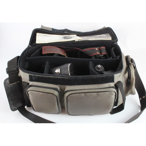 487 - Canon A-1 camera, with a group of lenses, accessories etc., contained in a camera bag