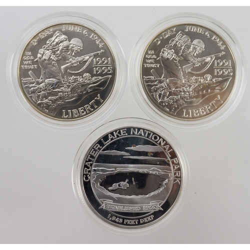 975 - USA (3) D-Day silver Dollars 1995 x2 UNC in capsules, along with a Greater Lake National Park white ... 