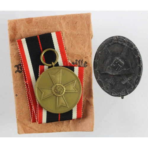 703 - German 3rd Reich War merit medal in packet and wound badge.