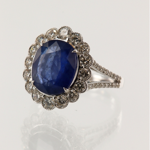 64 - White gold (tests 18ct) diamond and sapphire cluster ring, oval sapphire approx. 3.75ct, set with a ... 