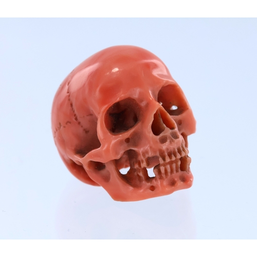 246 - Carved miniature skull in orange coral, high quality, well defined structures, hollowed underside wi... 