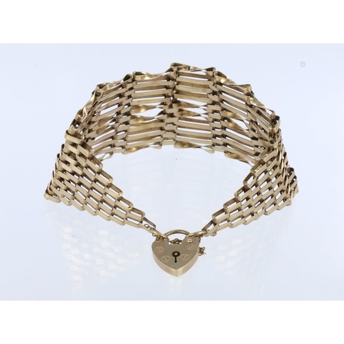 255 - 9ct yellow gold gate link bracelet, graduated form, tapering ten bars to one, fitted a heart padlock... 