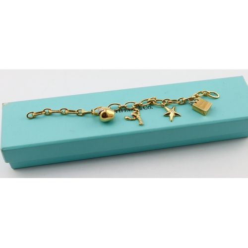 277 - Tiffany & Co. 18ct yellow gold charm bracelet, composed of oval trace links, each interchangeable, f... 