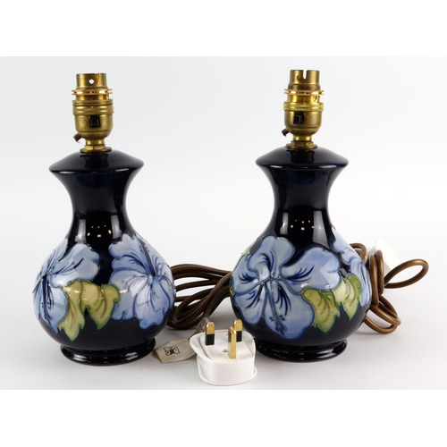 109 - Moorcroft. Two 'Hibiscus' pattern blue lamps, design by Walter Moorcroft, height 23cm approx includi... 