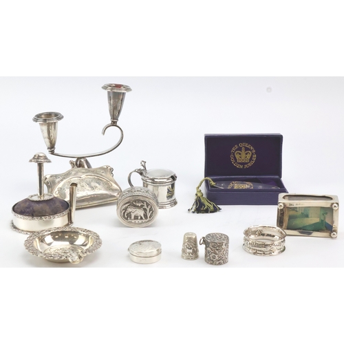 693 - Assortment of mixed silver / tests silver. Includes candle sticks, matchbox holder, napkin ring, pil... 