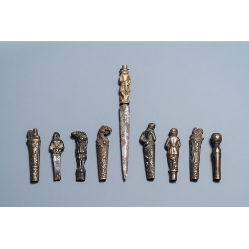 129 - Nine bronze and brass knife handles including one with a knife, 16/18th C.L.: 19 cm (the knife with ... 