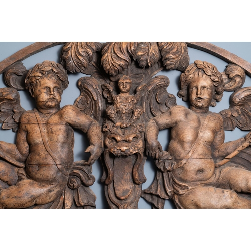 19 - A reticulated carved oak fronton with two winged cherubs holding a horn, France, 17th C.L.: 137 cm -... 