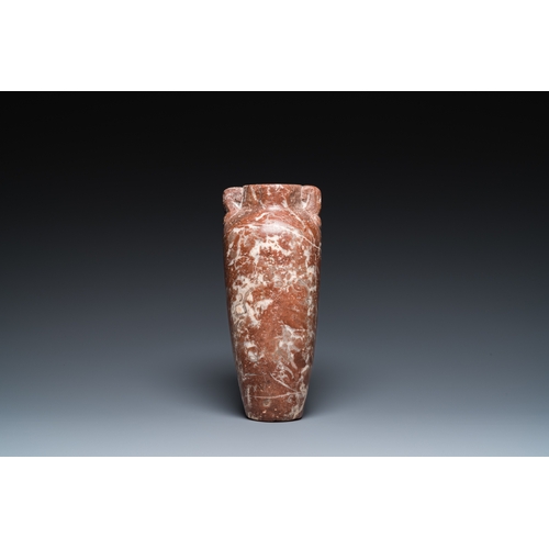 1406 - An Egyptian red Breccia jar, Predynastic period, 3500-2900 b.C.H.: 28,5 cm (the vase)
 
 Provenance:... 