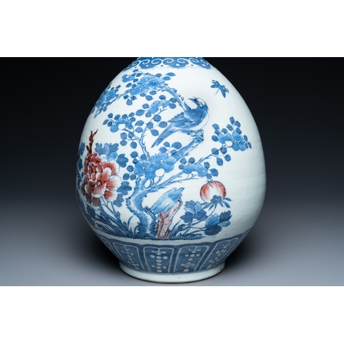 129 - A Chinese blue, white and copper-red bottle vase with a deer and birds among blossoming branches, 19... 