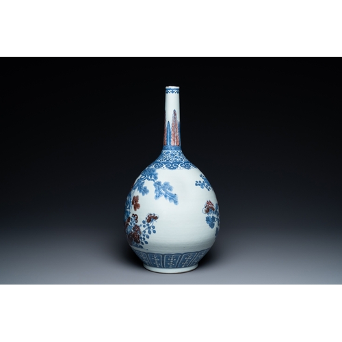 129 - A Chinese blue, white and copper-red bottle vase with a deer and birds among blossoming branches, 19... 