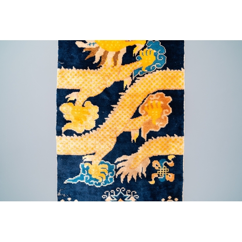 434 - A Chinese silk 'dragons' carpet, 19th C.Dim.: 183 x 74 cm (incl. frills)