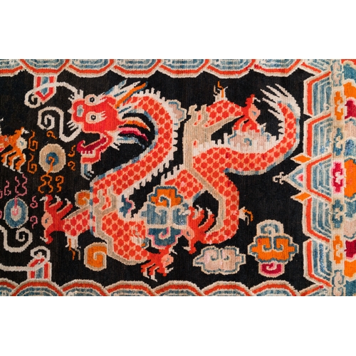 438 - A Tibetan rug with two dragons chasing the pearl of wisdom, 19th C.Dim.: 173,5 x 91,5 cm... 