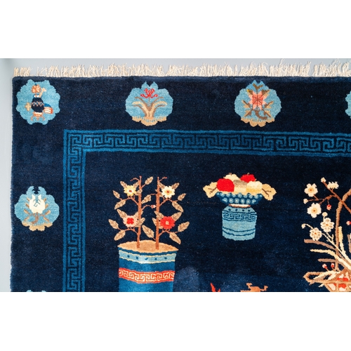 440 - A large Chinese blue-ground 'antiquities' rug, 19th C.Dim.: 264 x 183 cm (incl. frills)... 