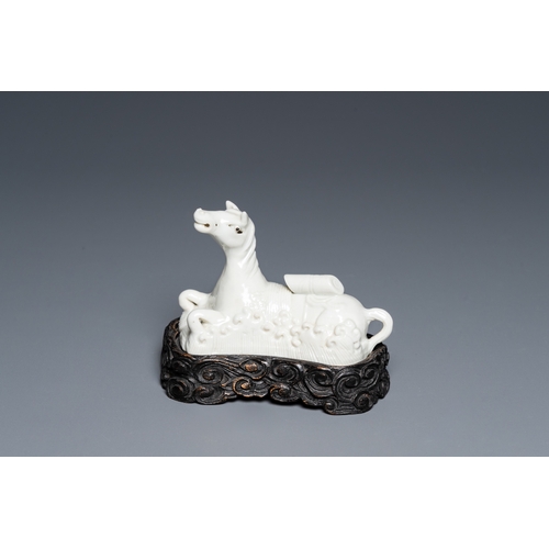 573 - A Chinese white-glazed brush rest in the shape of a resting horse in a wavy sea, 18th C.L.: 10,5 cm ... 