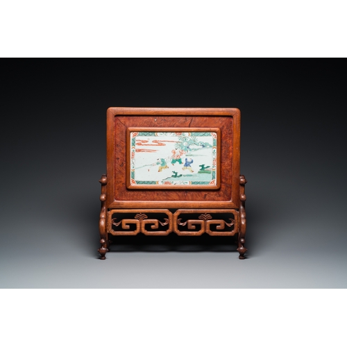 693 - A Chinese famille verte plaque set in a partly huanghuali wooden table screen, KangxiH.: 43 cm - L.:... 