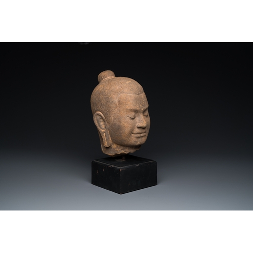 822 - A Khmer stone head of Jayavarman VII in Bayon-style, Cambodia, probably 13th C.H.: 38 cm (incl. stan... 