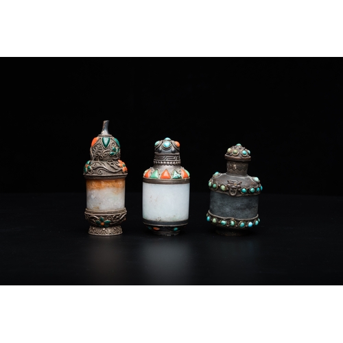 961 - Four Chinese inlaid silver-mounted jade snuff bottles, 19/20th C.H.: 10 cm - Dia.: 5,5 cm (the round... 