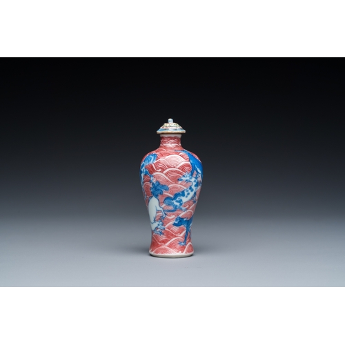 975 - A Chinese blue, white and copper-red 'dogs' snuff bottle, 19th C.H.: 8 cm