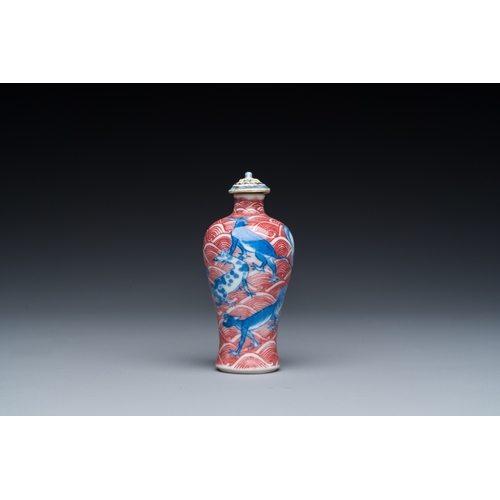 975 - A Chinese blue, white and copper-red 'dogs' snuff bottle, 19th C.H.: 8 cm