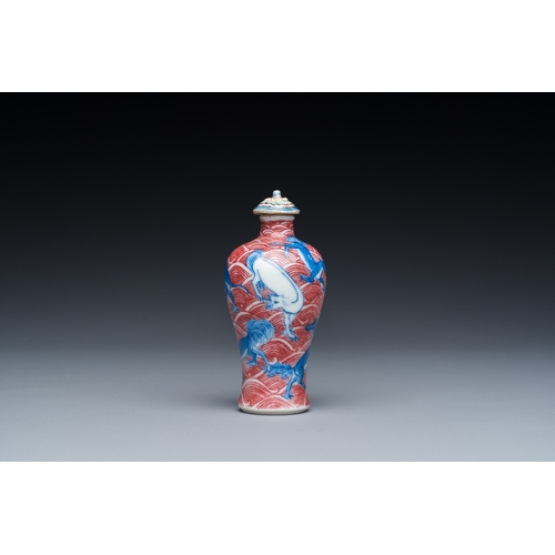 975 - A Chinese blue, white and copper-red 'dogs' snuff bottle, 19th C.H.: 8 cm