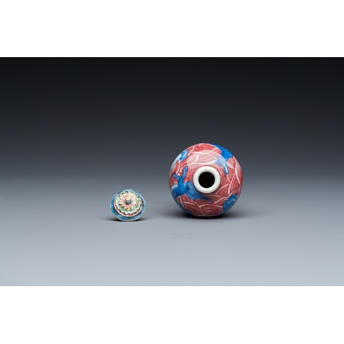 975 - A Chinese blue, white and copper-red 'dogs' snuff bottle, 19th C.H.: 8 cm