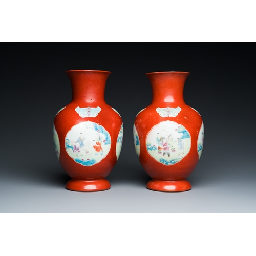 77 - A pair of Chinese coral-ground famille rose vases with medallions showing playing boys, 18/19th C.De... 