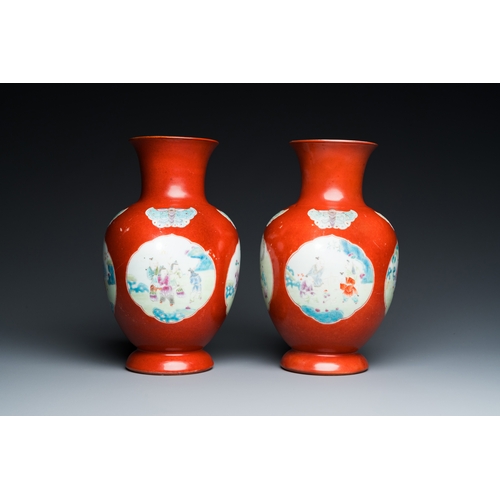 77 - A pair of Chinese coral-ground famille rose vases with medallions showing playing boys, 18/19th C.De... 