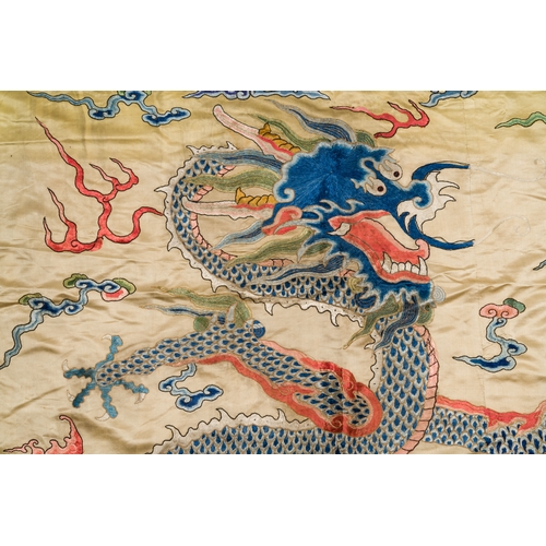 105 - A large Chinese yellow-ground silk embroidery decorated with three five-clawed dragons, 19th C.Descr... 