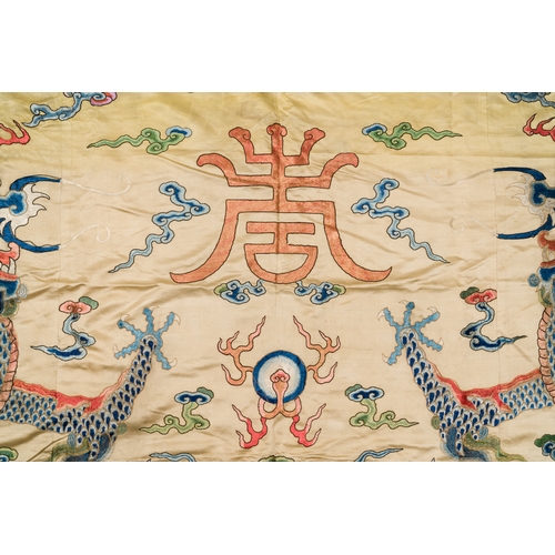 105 - A large Chinese yellow-ground silk embroidery decorated with three five-clawed dragons, 19th C.Descr... 