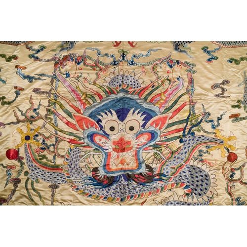 105 - A large Chinese yellow-ground silk embroidery decorated with three five-clawed dragons, 19th C.Descr... 