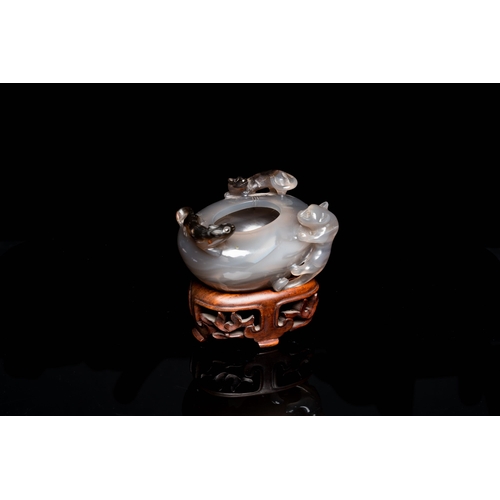 512 - A Chinese agate water pot with Buddhist lions on a carved wooden stand, 19th C.Description:Dim.: 8 x... 