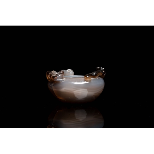 512 - A Chinese agate water pot with Buddhist lions on a carved wooden stand, 19th C.Description:Dim.: 8 x... 