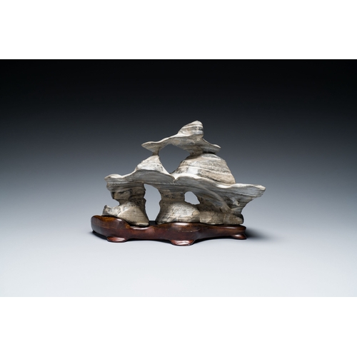 517 - A Chinese grey lingbi stone scholar's rock on wooden stand, 19/20th C.Description:Dim.: 24,5 x 14,5 ... 