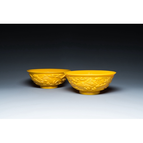 578 - A pair of Chinese yellow Beijing glass bowls with figures in mountainous landscapes, 19/20th C.Descr... 