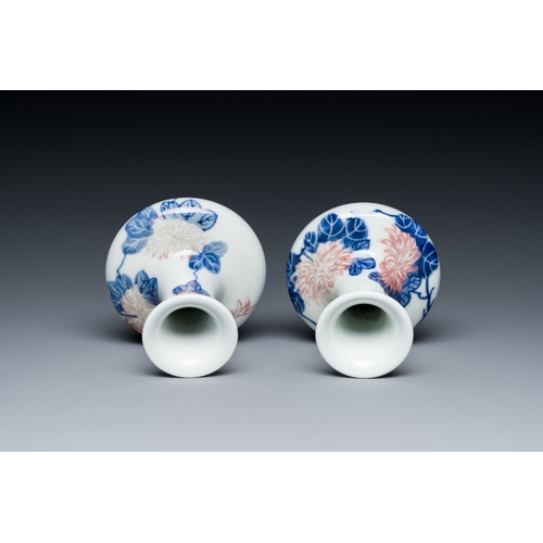 589 - A pair of Chinese blue, white and copper-red vases with floral design, Qianlong mark, 19/20th C.Desc... 