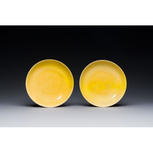 166 - A pair of Chinese monochrome yellow-glazed saucers with incised designs of pine and cranes, Yongzhen... 