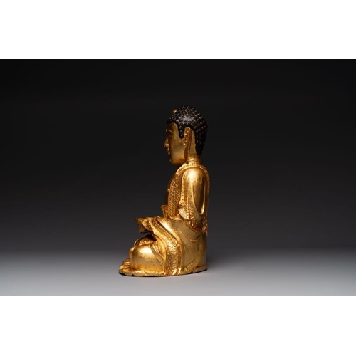 145 - A large Sino-Tibetan gilt bronze Buddha on wooden stand, MingH.: 46,5 cm (incl. stand)H.: 39 cm (exc... 