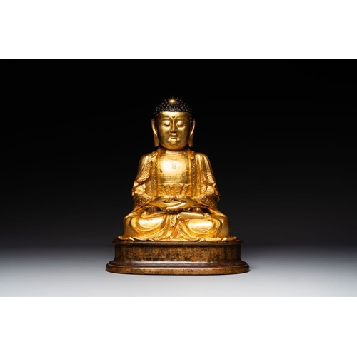 145 - A large Sino-Tibetan gilt bronze Buddha on wooden stand, MingH.: 46,5 cm (incl. stand)H.: 39 cm (exc... 