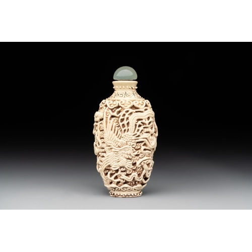 539 - A Chinese moulded cream-glazed 'dragon and phoenix' snuff bottle, Jiaqing mark, 19th C.H.: 7,3 cm (i... 