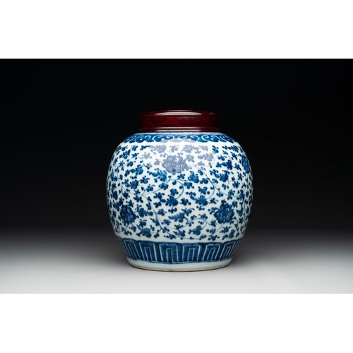 923 - A Chinese blue and white 'flower scroll' jar with a wooden cover, QianlongH.: 23,5 (incl. cover)The ... 