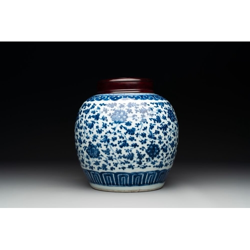 923 - A Chinese blue and white 'flower scroll' jar with a wooden cover, QianlongH.: 23,5 (incl. cover)The ... 