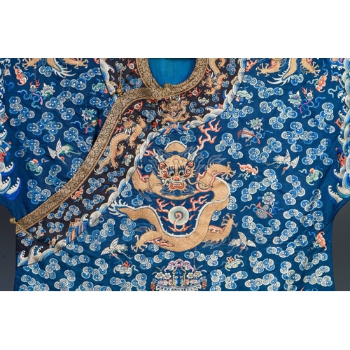 1062 - A Chinese gold thread embroidered blue-ground silk 'dragon' robe, 19th C.Dim.:226,5 x 140 cm
... 