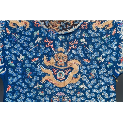 1062 - A Chinese gold thread embroidered blue-ground silk 'dragon' robe, 19th C.Dim.:226,5 x 140 cm
... 