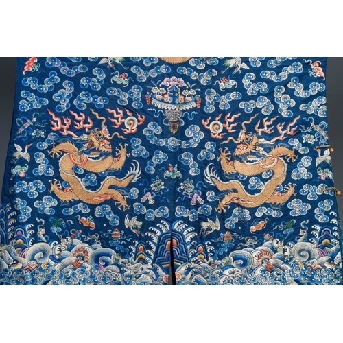 1062 - A Chinese gold thread embroidered blue-ground silk 'dragon' robe, 19th C.Dim.:226,5 x 140 cm
... 